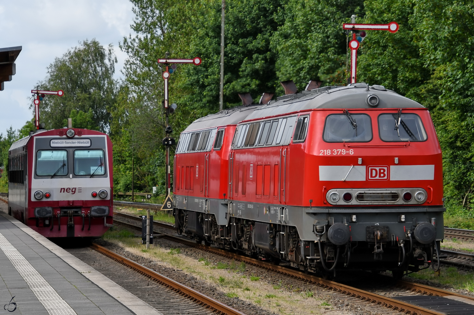 Die Diesellokomotiven 218 379-6 und 218 397-8 sind hier im Juni 2024 bei Rangieren am Niebüller in Niebüll zu sehen, während der Dieseltriebwagen T4 (627 103-4) auf die Abfahrt nach Tønder wartet.