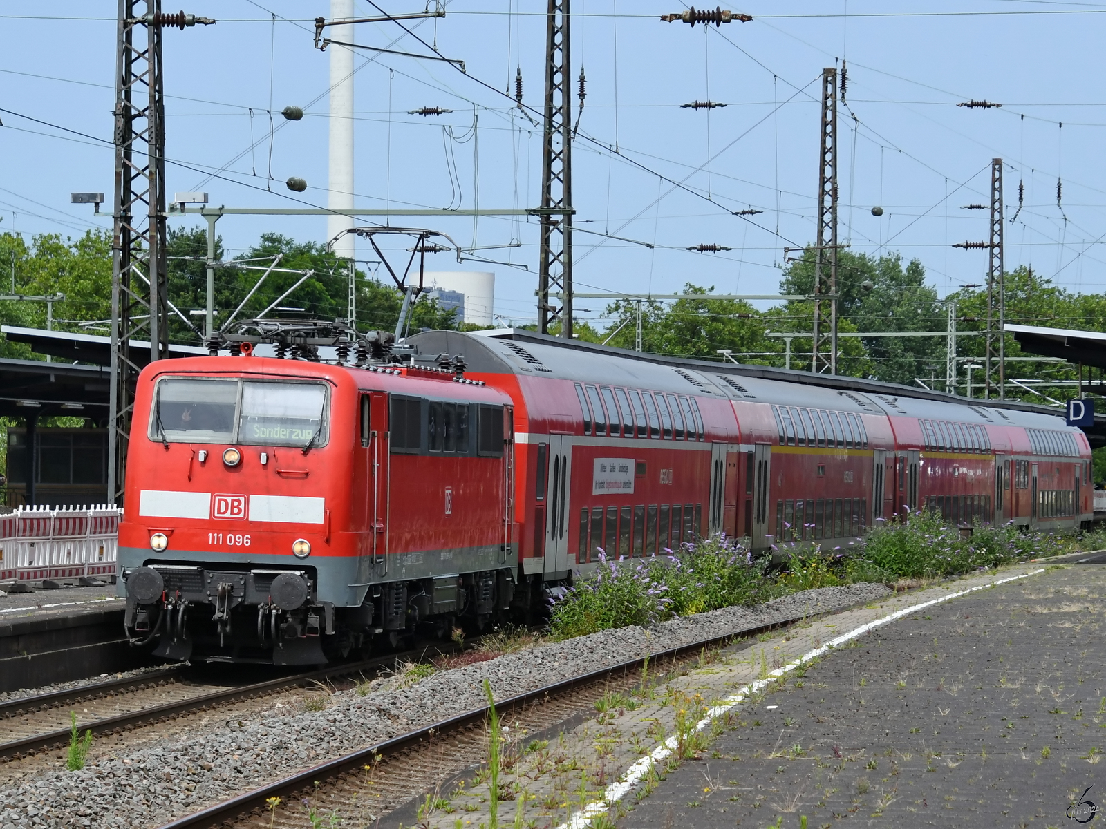 Die Fussball-EM 2024 brachte wieder einige für das Ruhrgebiet mittlerweile ungewöhnliche Zugkombinationen an den Start. Hier zieht die Elektrolokomotive 111 096 eine Doppelstockeinheit in Richtung Köln. (Wanne-Eickel, Juni 2024)