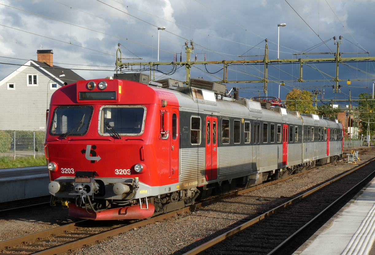 Farbenprächtiger E-Triebzug wartet in der Abendsonne vor den Gewitterwolken im Bahnhof Kristinehamn auf den nächsten Einsatz. Kristinehamn, 12.9.2024