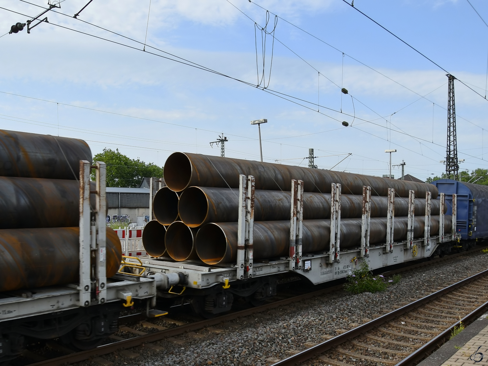 Im Bild ein mit Rohren beladener Flachwagen der Gattung Snps (31 56 4723 007-9). (Wanne-Eickel, Juni 2024)