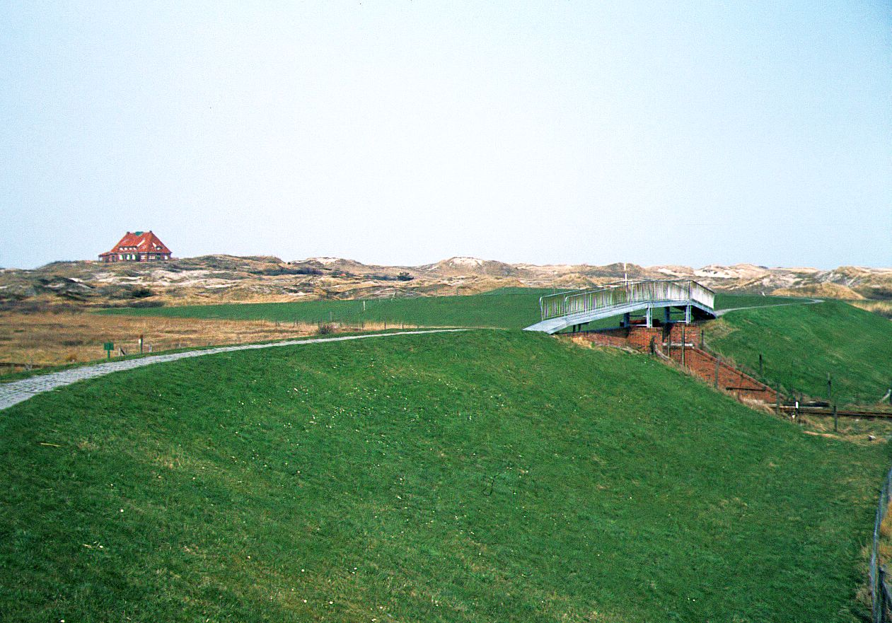 Inselbahn Spiekeroog__April 1984. Fußweg und Brücke über das Inselbahn-Deichtor.