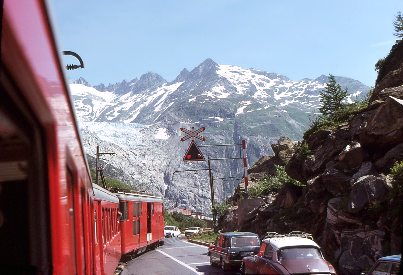 Matterhorn-Gotthard-Bahn - damals war der Gletscher (Rhonegletscher) noch zu sehen, als der Regelzug (allerdings nur im Sommer) die Bergstrecke über die Furka noch befuhr. Im Bild Gletsch, mit Triebwagen Deh4/4 I 53. 28. Juli 1975. Da machte es noch Sinn, vom  Glacier Express  zu sprechen. Heute hat sich leider der Gletscher so weit zurückgezogen, dass er auch aus der Dampfbahn Furka Bergstrecke nicht mehr zu erkennen ist. 