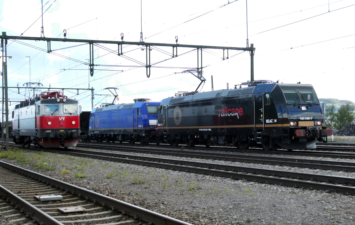 Rc6 1328 vom Regionalzug von Lulea nach Narvik setzt im Bahnhof Kiruna um, währenddem im Hintergrund eine Doppeltraktion auf die Abfahrt wartet. Kiruna, 12.8.2024