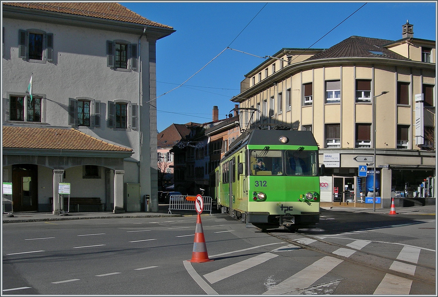 Trotz Umleitung und Fahrverbot - die Züge der A-L fahren seit heute wieder durch die Altstadt von Aigle. 
Der TPC BDeh 4/4 312 verlässt die engen Gassen von Aigle und erreicht als R 70 340 nach Leysin Grand Hôtel den Halt Aigle-Place-du-Marché (A-L). 

1. Dezember 2024