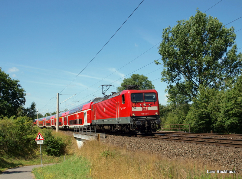 112 179-7 legt sich am 16.07.09 mit dem RE 21414 Hamburg Hbf - Lbeck Hbf kurz nach der Ausfahrt aus Bad Oldesloe in eine leichte Rechtskurve, beschleunigt nun auf 140 km/h und wird in 6 Minuten Reinfeld (Holst.) erreichen.