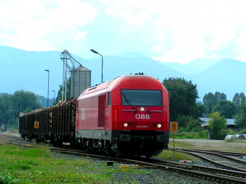 2016 046-1 zieht gemchlich die 4 Rundholzwagen durch die Langssamfahrstelle (Bhf. Viktring), was ein lautes  Raunzen  der warteten Fugnger am geschlossenen Bahnbergang mit sich zog, und wobei einige trotzdem noch die Gleise vor dem Zug berquerten;; 080924