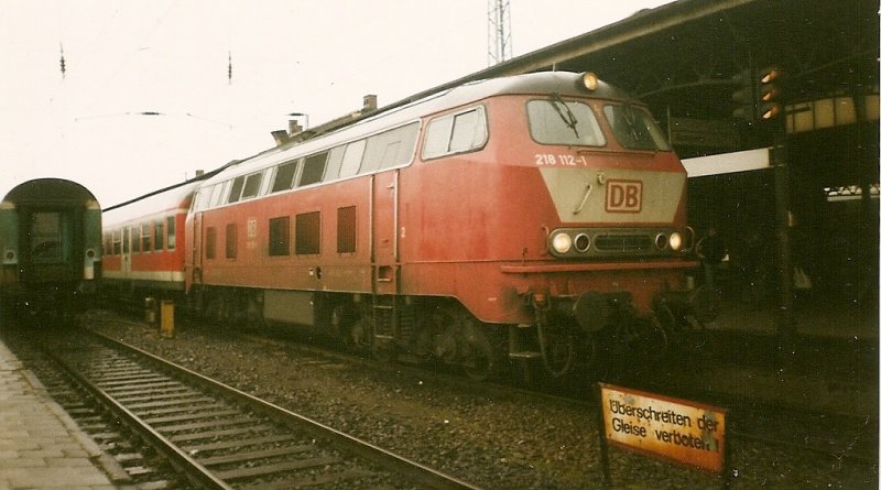 218 112 im Mrz 1999 vor einem Regionalexpress Rostock-Kiel im Rostocker Hbf. 