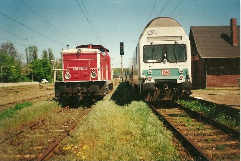 346 834 wartete auf Ausfahrt whrend Rechts eine Regionalbahn nach Binz im Mai 1999 den Bahnhof Bergen/Rgen verlie.