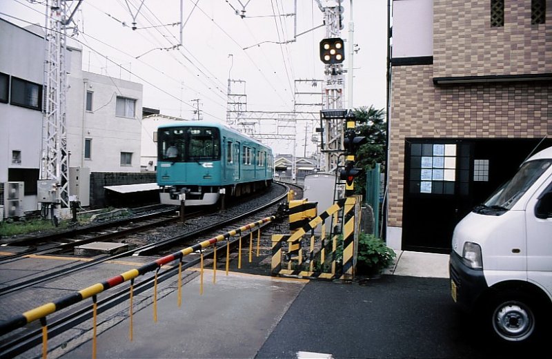 Der Keihan-Konzern.  Keihan  heisst  Kyoto und Osaka .Der Keihan-Konzern mit seinen 75 Unterfirmen beteibt Warenhäuser, Verkehrsdienste, Reisebüros, Hotels, Shopping Malls, Sportanlagen, Restaurants, Vergnügungsparks, und besitzt Immobilienfirmen und technologische Firmen. Er bietet zwischen Osaka und Kyoto mit einer Fülle von Zugsgattungen auf seinen Linien mit 1435mm-Spur dichteste Verbindungen an. Hier fährt ein Zug Serie 10000 (6 Züge, Baujahre 2002-06)aus der Ortschaft Ôbaku aus; Wagen 10001, 4.Oktober 2006.