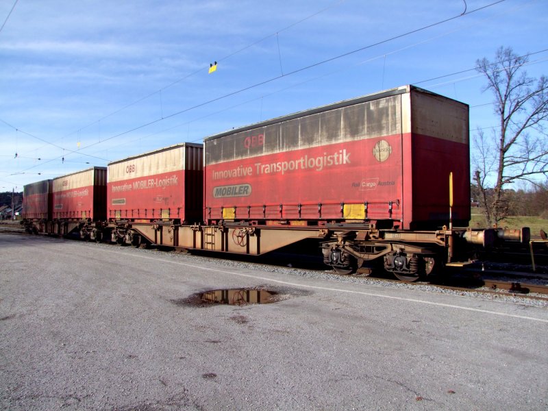 Drehgestellflachwagen in Sonderbauart Sggmrrss(2x60)[3181493210-4] ist mit 4 Mobiler beladen, und steht am Bhf. Redl-Zipf;090124