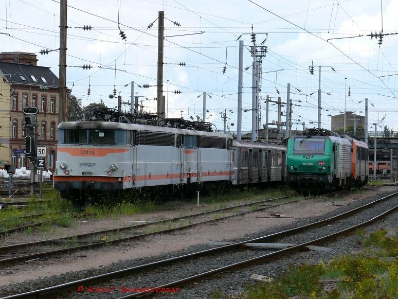 Drei Generationen Zweisystemelloks fr den innerfranzsischen Verkehr in Thionville auf einem Bild.
Links im Bild die BB25123 und eine weitere Lok der Reihe BB25100. Diese Reihe wurde ab 1964 in Dienst gestellt und 2007 ausgemustert.
Rechts die grne BB27016 aus der ab 2002 beschafften Reihe BB27000 und dahinter in oranger Farbe eine Lok der ab 1988 beschafften Reihe BB26000. 

30.07.2007 Thionville