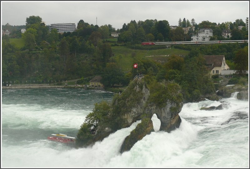 Ein IR von Schaffahausen nach Zrich passiert die Rheinflle bei Neuhausen. Das Boot unten links bringt Besucher auf den Felsen in Strommitte. (14.09.2008)