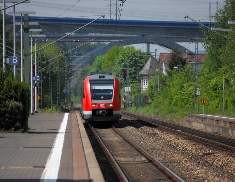 Hauptbahnromantik (XXIV, untere Lahntalbahn). Wer Jacques Tatis „Mon Oncle“ kennt, weiß, wie die moderne Welt mit der verträumten Nostalgiewelt verbunden ist. Nämlich gar nicht. Den gleichen Anschluss and die moderne Welt gibt es hier in Eschhofen, nämlich einen 15-minütigen Fußweg zum ICE-Bahnhof Limburg-Süd. 612 146 nach Gießen fährt aus Gleis 2 ein. Dabei hat er respektvollen Abstand zur modernen Welt oben gehalten. Ein ICE donnerte theatralisch nur eine Minute zuvor mit 300 Sachen über die Brücke im Hintergrund. Jetzt fehlt eigentlich nur noch, dass  der Kanarienvogel singt, wenn der Lokführer vor Abfahrt das Fenster öffnet ‒ ups, bin schon wieder bei Jacques Tati. (25. April 2009, 11:52)