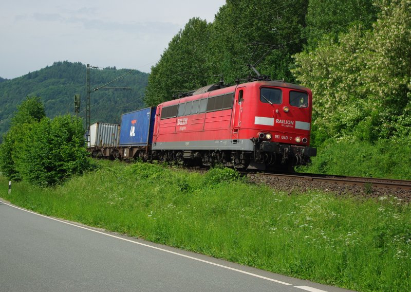 Kurz vor Bad Sooden-Allendorf, aus Richtung Bebra kommend, legt sich 151 043-7 mit ihrem Conteinerzug galant in die Kurve. 26.05.2009.