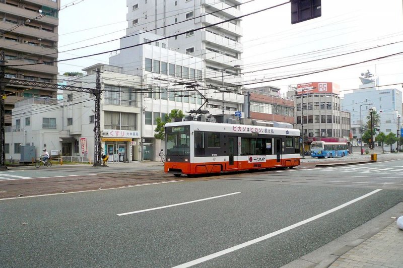 Matsuyama Strassenbahn, Serie 2101-2110: Wagen 2106 an der Kreuzung mit der Iyo-Bahn, denen der Strassenbahnbetrieb von Matsuyama gehrt. Die Iyo-Bahn betreibt mehrere Vorortslinien um Matsuyama herum. 18.September 2009.