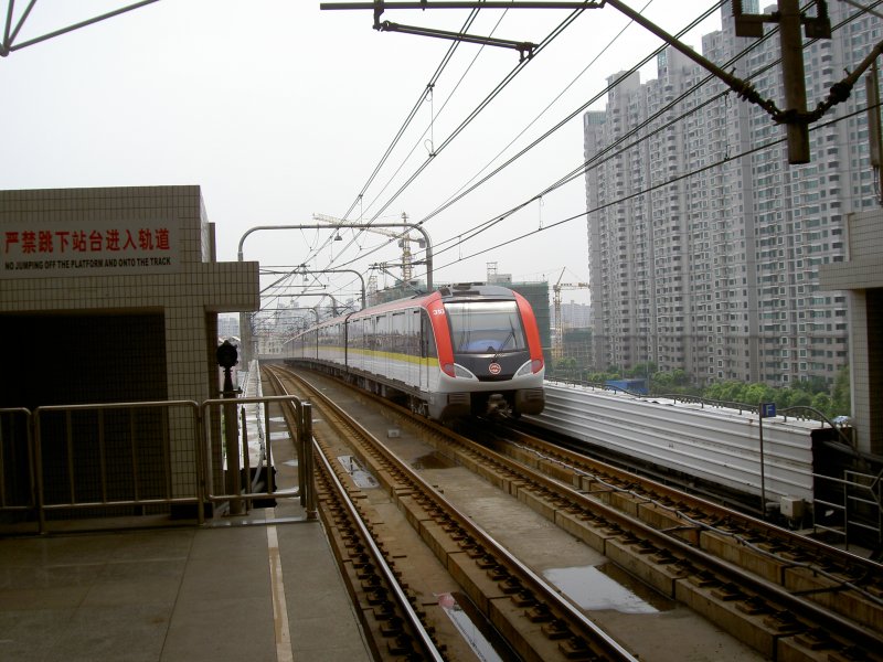 Metrozug 310 Shanghai Linie 3 (gelb) am 05.08.2007 in Shanghai Cao Xi Lu (nhe Fussballstadion) bei der Ausfahrt in Richtung Sdbahnhof.