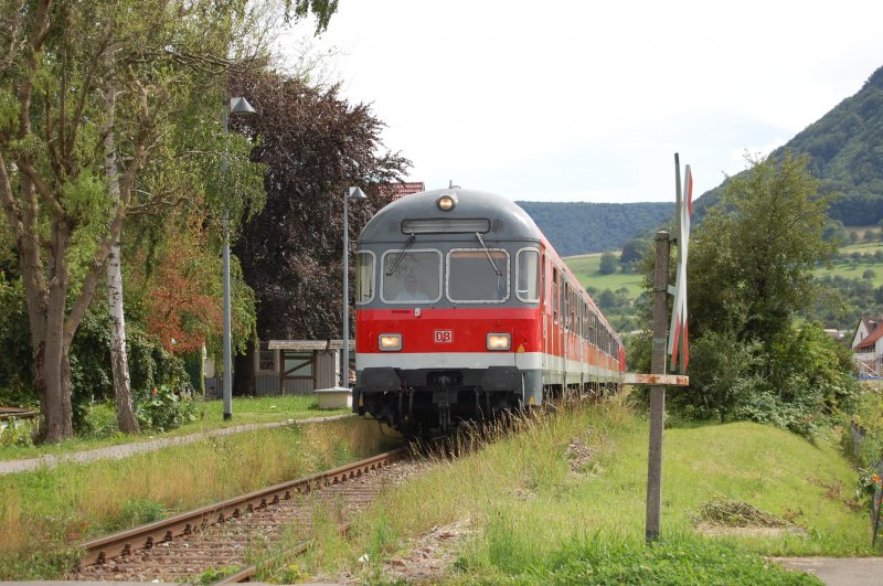 Mit einem lauten und langen Pfiff berquert am 30.7.2009 eine RB von Oberlenningen nach Wendlingen einen unbeschrankten Bahnbergang in Owen.