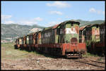 Ende des Fahrbetriebs im Bahnhof Prrenjas in Albanien nahe der mazedonischen Grenze. Ca. 15 Cmellaks und die V 2003 ex V 200124 stehen dort im Freien und rosten vor sich hin. Die Aufnahme machte ich am 18.5.2017. Im Vordergrund könnte es sich um T 6991031 handeln?!