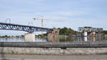 Links die neue Brücke über die Maas in Visé, rechts, aufgebockt auf einem schwimmenden Ponton, ein Stück der alten Brücke.