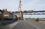 Infrabel-Lok 6274 schiebt den Schotterzug in Schritttempo über die neue Maasbrücke in Visé.