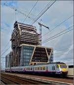 Am Bahnhof in Hasselt entsteht ein sehr eigenwilliges Hochhaus, whrend die AM80 333 am 11.03.2011 daran vorbeifhrt. (Jeanny) 