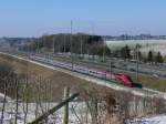 Thalys 9421 Paris-Nord - Kln hat soeben den 6 km langen Tunnel von Soumagne verlassen und fhrt nun entlang der Autobahn E40 nach Aachen. Im Hintergrund erkennt man die Ortschaft Herve, Namensgeberin des bekannten Herver Kses, den man nach Mglichkeit nicht offen liegen lassen sollte, ansonsten eine grndliche Durchlftung der gesamten Wohnung unumgnglich wre. Hier aufgenommen am 07/03/2010 in Hhe vom Autobahnkreuz Battice.