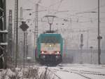 186 201 kommt von Belgien die Montzenroute runter mit leeren vierachsigen Rungenwagons bei dichten Schneetreiben in den Westbahnhof Aachen.