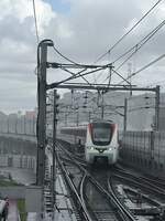 2024.07.20 DongGuan Rail Transit, Line 2's train turning back at HuMan Railway Station in sunshower.