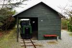 Der kleine Zug der Museumsbahn Hanstholm, aufgenommen am Vormittag des 17.04.2014. Er verkehrt auf einem etwas über 1100 Meter langen Rundkurs, welcher auf den Gleisen der ehemaligen Munitionsbahn der Festungsanlage Hanstholm eingerichtet wurde und durchquert dabei sowohl malerische Küstenlandschaft, als auch einen Munitions- sowie einen der Geschützbunker, welche zum heutigen Museumscenter gehören. Die genannte Festungsanlage wurde im Rahmen der Errichtung des  Atlantikwalls  zwischen 1940 und 1943 erbaut und verfügte über vier schwere 38 cm-Schiffsgeschütze der Gattung SKC 34, wie sie auch auf den Schlachtschiffen  Bismarck  und  Tirpitz  verwendet wurden, sowie über zahlreiche Flak-Stellungen. Gemeinsam mit der Schwesteranlage  Vara  im norwegischen Kristianssand, diente die sogenannte  II. Batterie  der Überwachung und Kontrolle der Seewege des Skagerrags und erzielte mit ihren 500-800kg schweren Granaten Reichweiten von 44-55 Kilometern! Da diese aus Sicherheitsgründen in einem separaten Bunker gelagert wurden, war der Bau der Munitionsbahn notwendig, um sowohl die Granaten, als auch deren Treibladungen zu den Geschützstellungen transportieren zu können.
1971 kam diese Bahn sogar zu Filmehren, als die Nordisk-Film unter der Regie von Erik Balling hier und im benachbarten Ort Vigsø, viele Szenen der Krimikomödie  Die Olsenbande fährt nach Jütland  drehte. Hierzu gibt es auch eine kleine Ausstellung im nur wenige Meter entfernten Bunkermuseum und zwar in einem der Räume des darunterliegenden, nahezu vollständig erhaltenen, Geschützbunkers. Apropos  Olsenbande : 1975 folgte der Film  Die Olsenbande stellt die Weichen , welcher größtenteils auf den Gleisanlagen in und um Kopenhagen spielt und ein wirkliches  Muß  für jeden Bahnfan ist. Beide Filme sind sowohl auf DVD als auch, in digital remasterder Qualität, auf Blue-Ray erhältlich.