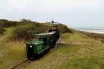 Ausfahrt des Zuges der Museumsbahn Hanstholm am 17.04.2014 aus dem Geschützbunker. Im Hintergrund ist der Hanstholmer Fähr- und Fischereihafen zu sehen.