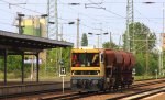 Ein Gleisarbeitsfahrzeug kommt mit drei Kohlewagen bei der durchfahrt Berlin-Flughafen-Schnefeld  und fhrt in Richtung Potsdam bei Sonnenschein am 18.5.2012. 