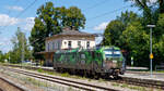 91 80 6193 234 (Offroad) passiert als Lz am 15.08.2024 das leerstehende Empfangsgebäude des Bahnhofs Aßling.