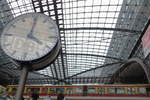 Ein Bahnhof aus Glas. In der Uhr spiegelt sich das Logo der Deutschen Bahn, welches über dem Eingang des Bahnhofs platziert ist.

Berlin Hauptbahnhof, 17. Oktober 2016
