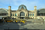 Blick auf das Empfangsgebäude von Dresden Hbf mit einer Tatra-T4D-MT-Einheit der Dresdner Verkehrsbetriebe AG (DVB) in der Haltestelle Hauptbahnhof.