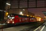 DB Cargo Coca Cola Zug am 17.12.23 in Frankfurt am Main Hbf mit Bombardier Traxx 185 207-8 und dem Coca Cola Truck auf einen Flachwagen im Dunkeln 