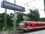 Das Bahnhofsschild von Germersheim mit einem VT 628 im Hintergrund. (26.06.2008)