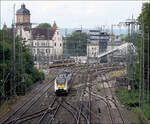 Die Gleise auf der Ostseite des Heilbronner Hauptbahnhofes - 

Hier werden niveaugleich die Gleise der Frankenbahn (Würzburg) sowie der Hohenlohebahn (Crailsheim) zusammengeführt. Der Talent II als MEX 18 nach Osterburken befindet sich gerade auf den Brücken über den durch die Stadt führenden Arm des Neckars.

Bei dem markanten Gebäude links handelt es sich um das ehemalige Postamt. Rechts ist ein Teil der neuen Fußgängerbrücke über die Gleise des Hauptbahnhofes erkennbar.

Der Fotostandort befindet sich ebenfalls auf einer modernen Fußgängerbrücke im Bereich des Heilbronner Bildungszentrums.

16.07.2024 (M