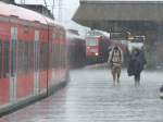 Bahnsteigsituation in Koblenz am 20.7.08, als urpltzlich starker Regen einstetzte und die Fahrgste, die nach Kln und Mnchengladbach wollten, dazu veranlasste, ber den unberdachten Bahnsteig zum Gleis 104 zu kommen. Die Zugeinheit (Re 11326 nach Mnchengladbach) links musste wegen Oberleitungsschaden ausfallen. (wenn ich richtig gehrt habe in Linz(Rhein) oder sowas).
Gegen 17.18 gings dann mit einer RB los.