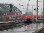 422 754 kommt als RE9 nach Aachen bei Regen in den Kölner Hbf eingefahren und stellt sich gleich hinter den Thalys welcher ebenfalls auf Gleis 9 steht.