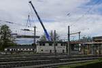 Um die aus dem Jahr 1901 stammende Thierschbrücke am Bahnhof von Lindau durch einen Neubau ersetzen zu können, muss zuerst die alte Brücke abgerissen werden. Am 22.10.2017 legt ein hinter dem Stellwerk stehender Mobilkran ein zuvor abgetrenntes und herausgezogenes Brückenteil für den späteren Abtransport ab.