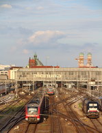 Mit der Frauenkirche und einigen Baukränen im Rücken verlassen 440 702/002-9 und 440 749/049-9 als RE 4086 (München Hbf - Passau Hbf) den Hauptbahnhof der Landeshauptstadt.