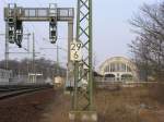 Bahnhof Potsdam Park Sanssouci, frher Wildpark, Signalausleger fr Vorsignalwiederholer, im Hintergrund der wieder aufgebaute Kaiserbahnhof, Nutzung durch die DB als Schulungszentrum fr Manager. 2 historische Wagen stehen seit 2/2005 bereits in der Halle. Sie sind in Noppenfolie verpackt (Baustaub).