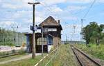 Blick auf den überdachten Zugang zum Bahnsteig sowie das Stellwerk von der Abzweigstelle Ra.