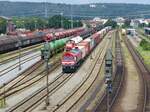 Ein Blick auf den Bahnhof Schwandorf am 28.6.2024. Im Vordergrund die DB Cargo Class 66  077 005-2 ( 9287 0077 005-2 F-DB ) mit einem Containerzug abfahrbereit in Richtung Süden.