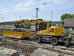 Ein Zweiwegebagger LIEBHERR 922 Rail ist hier mit einem Schwerlastkleinwagen auf Schienen zu sehen. (Wanne-Eickel, Juni 2024)