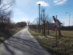 Das Andreaskreuz signaliert noch immer den Bahnübergang für die ehemalige Anschlußbahn in Quatzendorf(bei Sagard),am 22.März 2015,obwohl keine Gleise dort schon lange nicht mehr liegen.