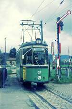 Straßenbahn Reutlingen__Die Straßenbahn in Reutlingen verkehrte das letzte Mal (auf den Linien 1 und 2) am 19. Oktober 1974. T2 (vermutlich, gemäß Werbung, Tw 56) auf Linie 1 von Eningen kommend überquert beim Südbhf. die Schienenkreuzung mit der Echaztalbahn Reutlingen-Pfullingen-Honau-Lichtenstein-Engstingen. Seit 1961 verkehrten hier Zahnrad-Schienenbusse VT 97, die von Reutlingen bis Ulm durchfahren konnten. 1969 wurde die Zahnradstrecke ab Honau eingestellt und bis Engstingen abgebaut. Zwischen Reutlingen und Honau verkehrten Schienenbusse noch bis 1980.    Vorbildlich, in weiser Voraussicht der 50 Jahre später praktizierten Persönlichkeitsschutzbestimmungen verdeckt der Fahrer sein Gesicht... Nein, so war es nicht. Vielmehr war es bei einzelnen Fahrern Ausdruck ihrer Enttäuschung über die Einstellung (1970 der nördlichen Linien 3 und 4 nach Altenburg bzw. Hagen) und der damals bereits diskutierten Einstellung der südlichen Linien 1 und 2, und über das vorausgehende viele Hin und Her mit verschiedenen Experimenten bei den Linienführungen. __24-06-1970