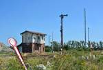 Blick auf das Stellwerk B1 in Barleben sowie das Ausfahrsignal Cäsar und den Bahnübergang. Im Vordergrund liegen 2 alte Formsignale die vor Jahren durch neue ersetzt wurden. 

Barleben 23.07.2019