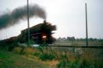 BR 43 vor einem Gterzug auf der Emslandstrecke bei Rheine, die Fahrleitungsmasten stehen schon.....