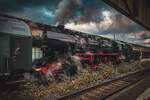 Eine historische Dampflok der Baureihe 52 steht dampfend im Zwickauer Hauptbahnhof.